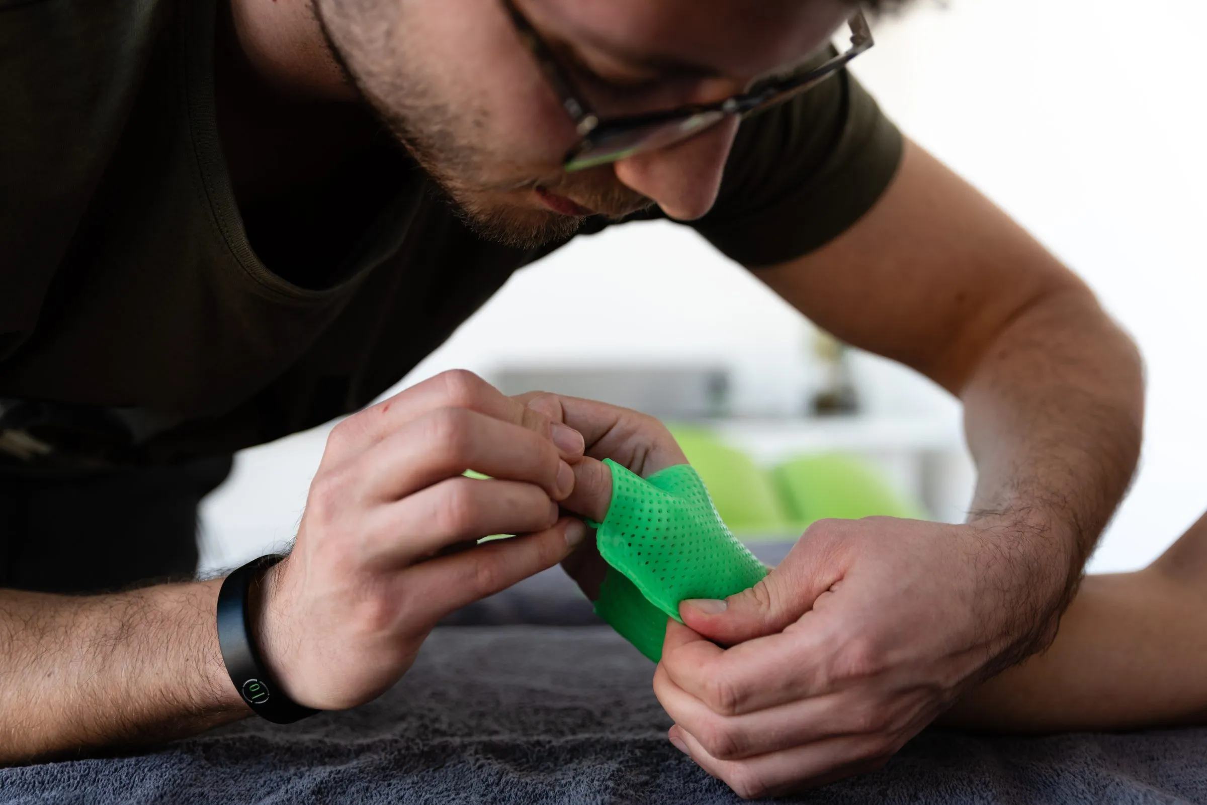Occupational therapist shaping a green hand splint on a patient’s hand