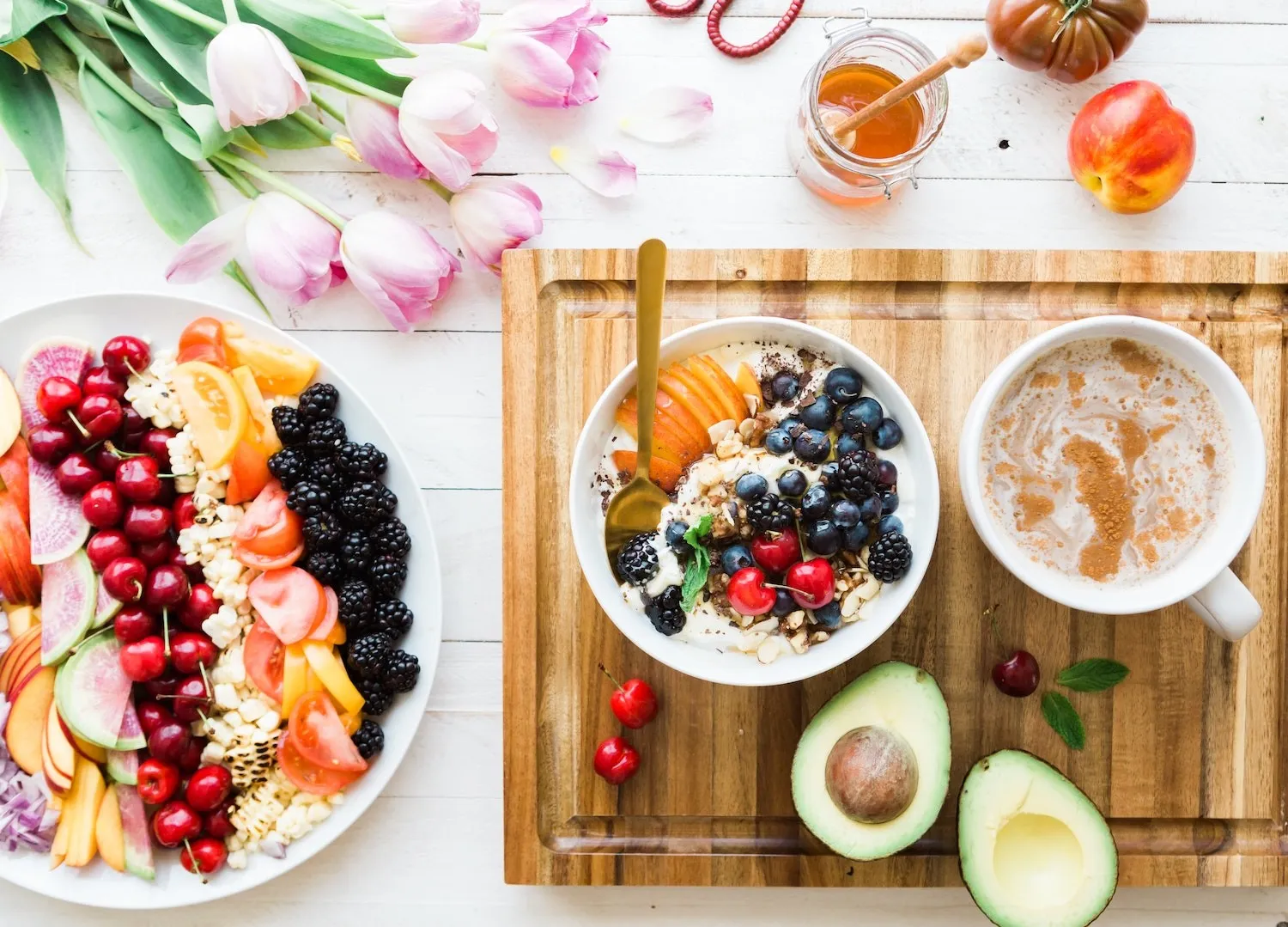 Breakfast table with fruit, a bowl, avocado and coffee