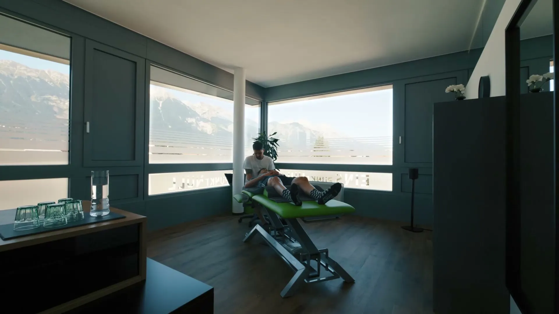 Treatment room at Physio 1.0 in Innsbruck with large windows and a view of the mountains