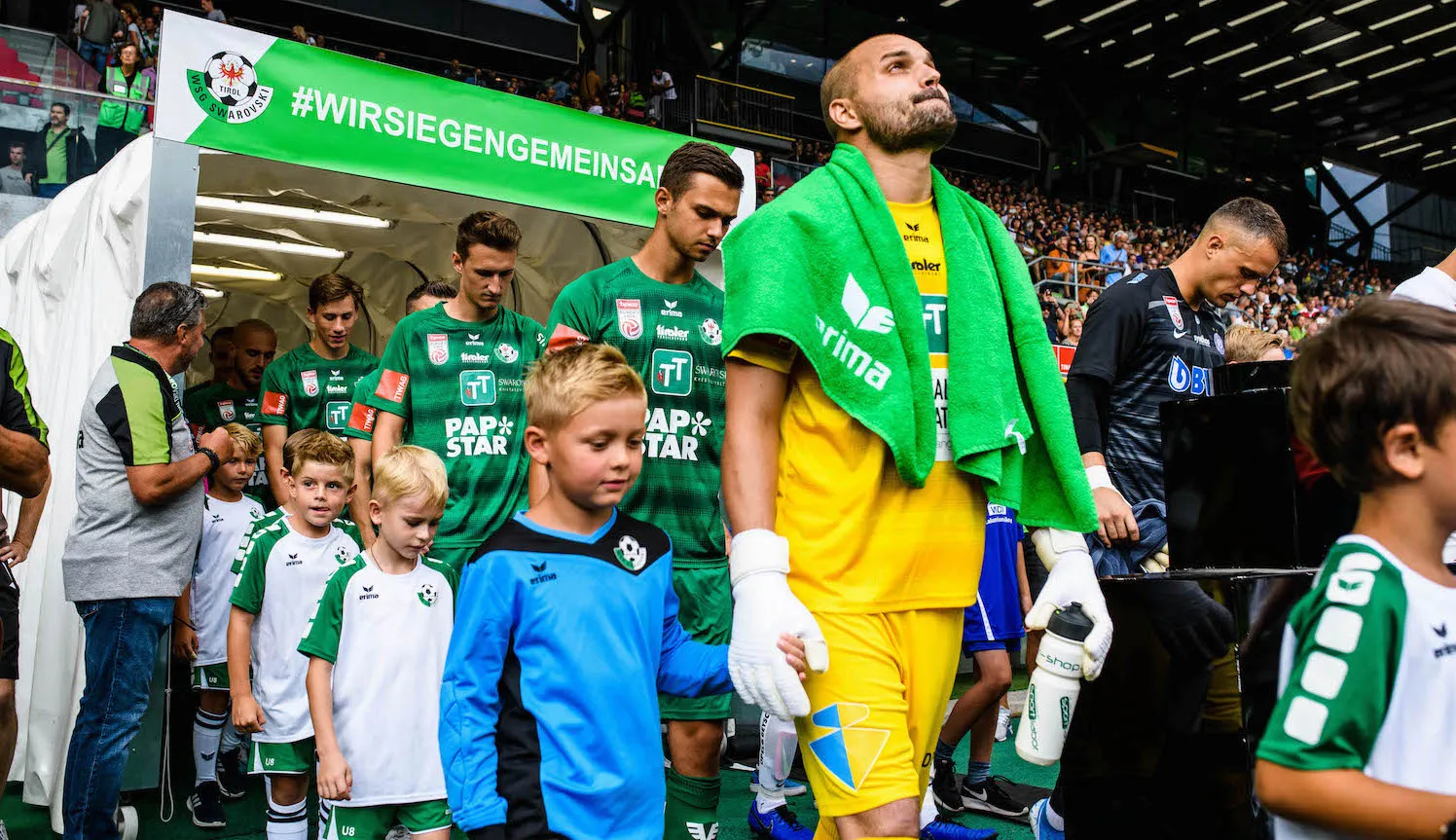 WSG Tirol players walking into the stadium with mascot children